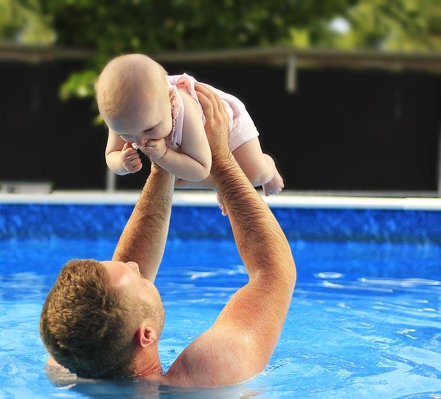 táta učí nemluvně plavat