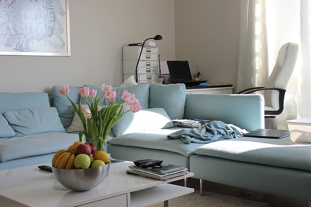 obývací pokoj se světle modrou sedačkou a pracovním koutkem